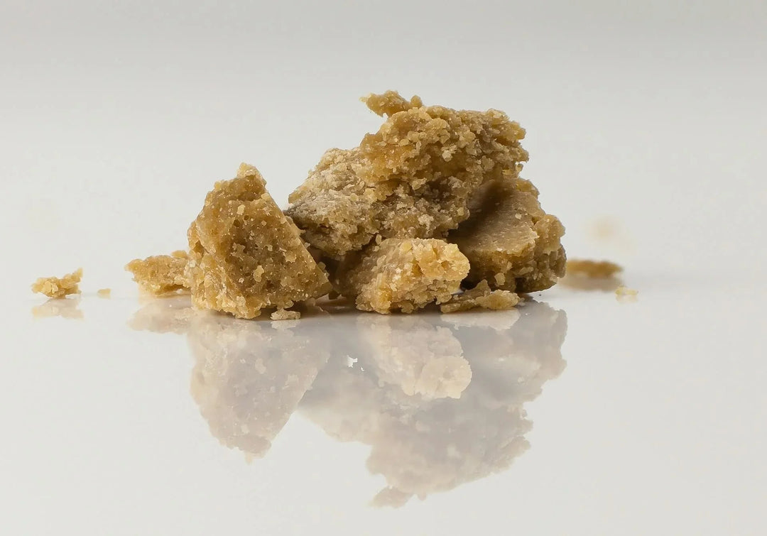 THCA concentrate crumble on white reflective surface
