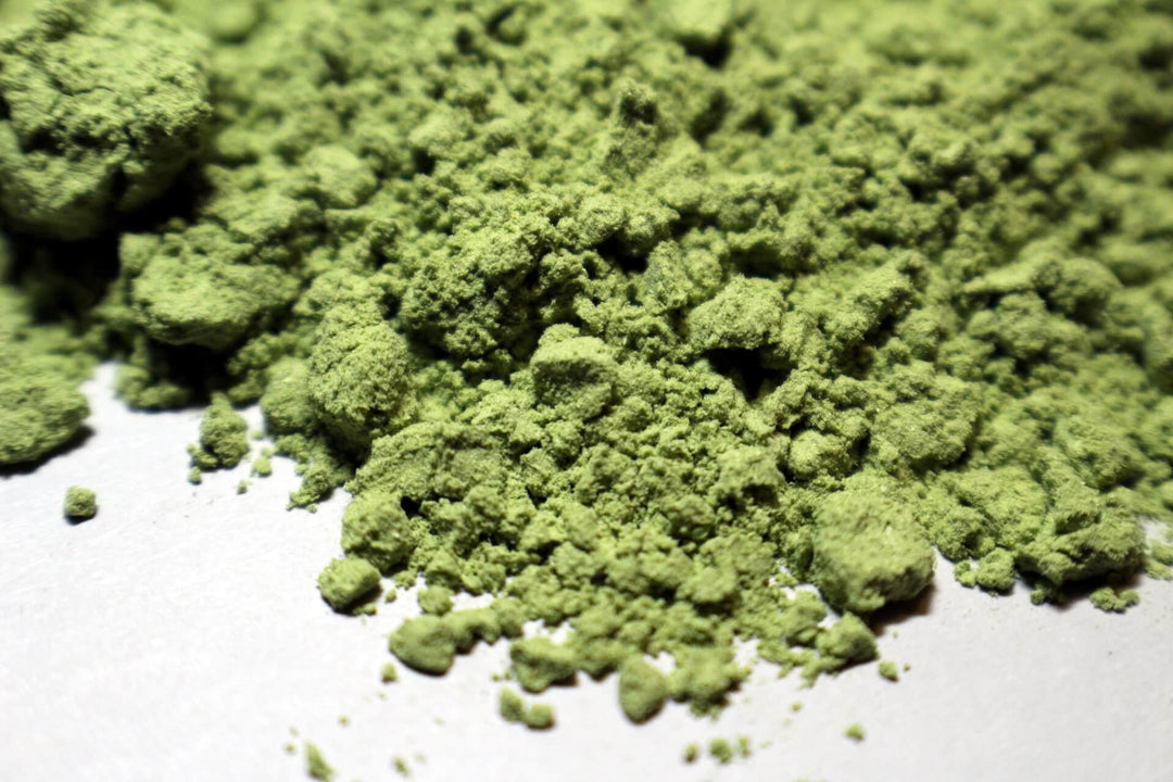 Close-up of green THCA powder on white surface