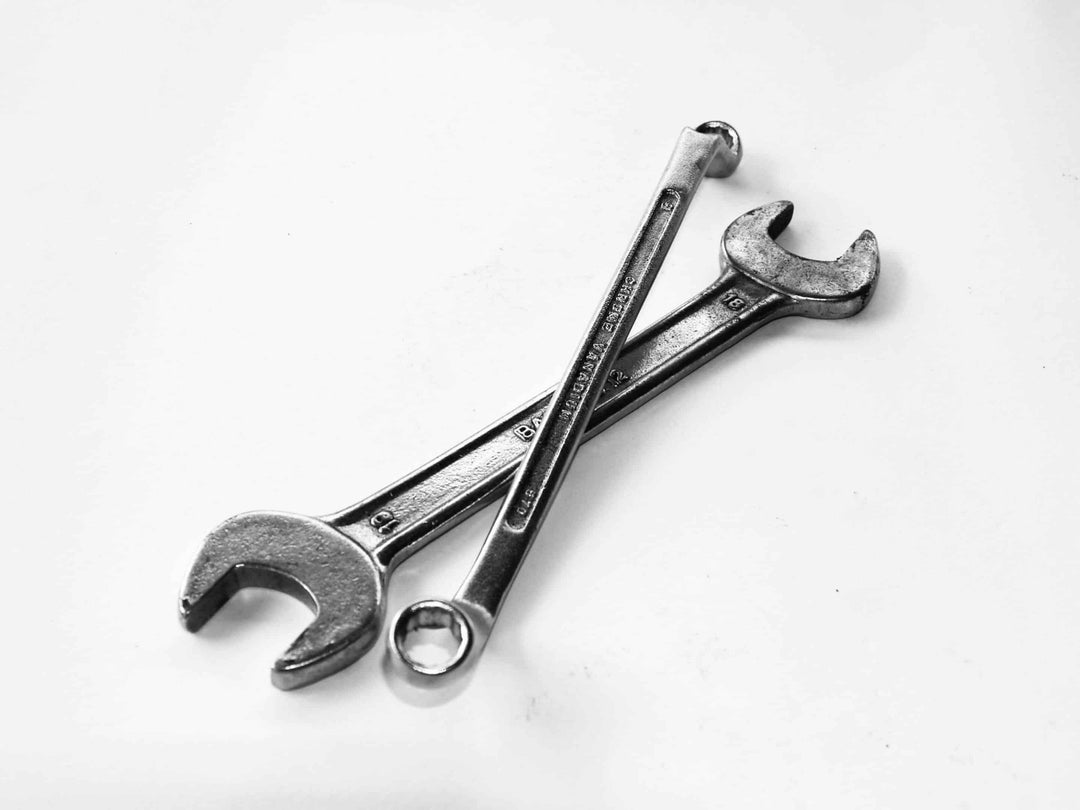 Two metal wrenches crossed on a white background, repair tools for fixing