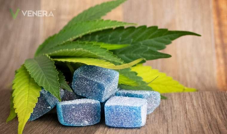 Blue Delta 8 THC gummies with cannabis leaves on wooden background, Venera branding